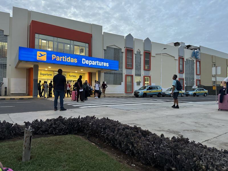 Exterior del pequeño aeropuerto de Sal, varias personas paradas en la puerta y otras saliendo de el