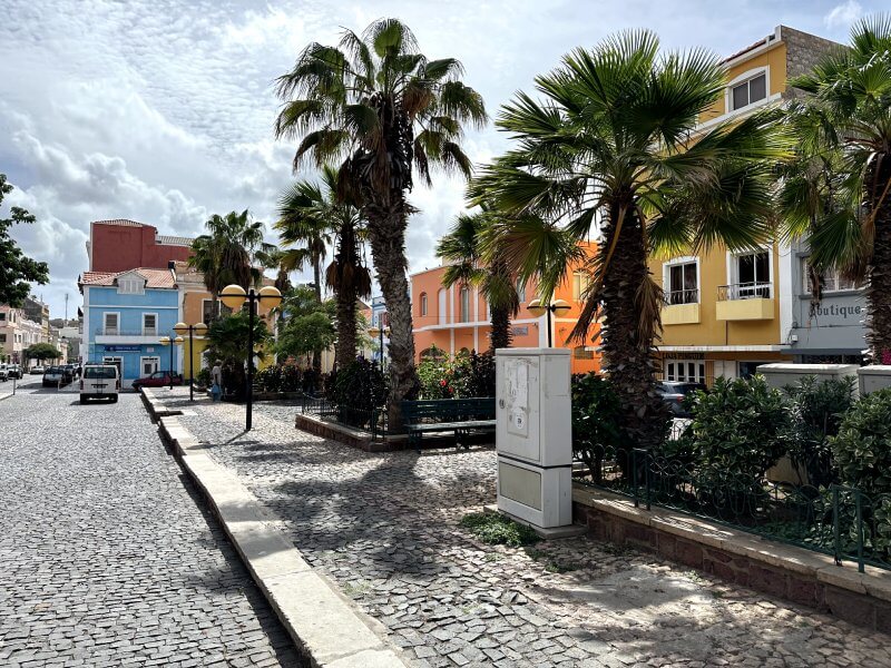 La praçina da Igreja Nossa Senhora da Luz de Mindelo, roedeada de palmeras y casas de colores tipicas de Cabo Verde