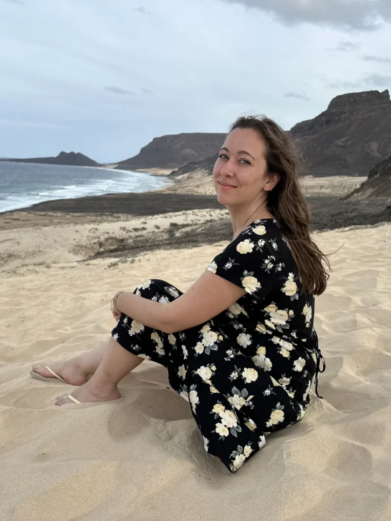 Sentada en las dunas de São Vicente frente al océano
