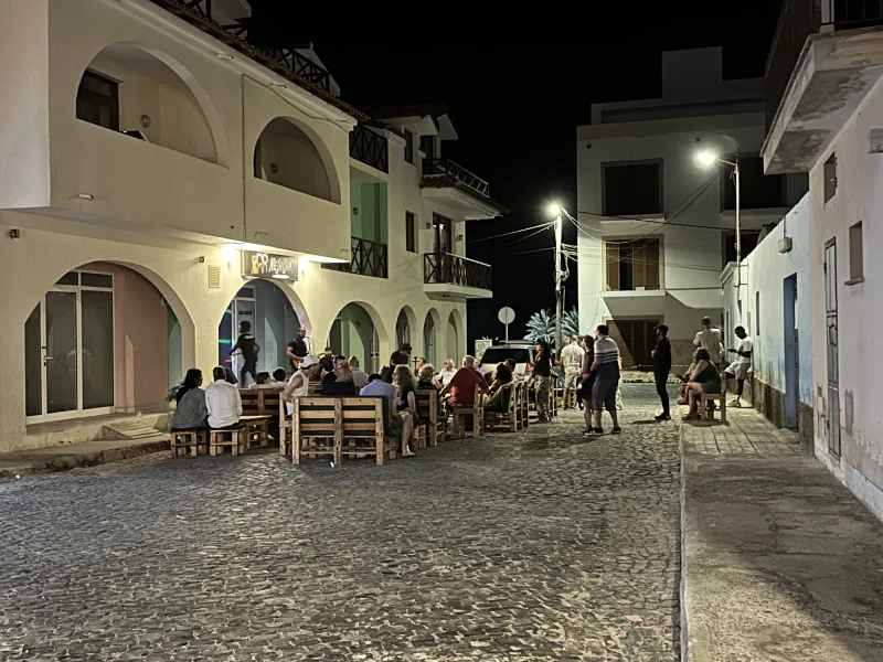 Música en directo en Santa Maria Varios turistas y locales sentados en la terraza de un local por la noche, disfrutando de la música en directo