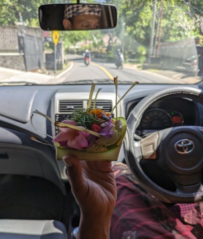 En el coche con nuestro guia de Bali que nos ayudo a organizar el viaje a Indonesia por libre nos muestra su ofrenda diaria