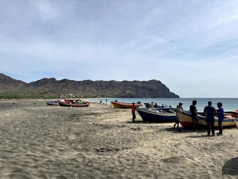 Barcas tradicionales en la arena de la playa de Sao Pedro, rodeadas por personas locales bajo un cielo despejado. Una parada en nuestra ruta de 7 dias por Cabo Verde