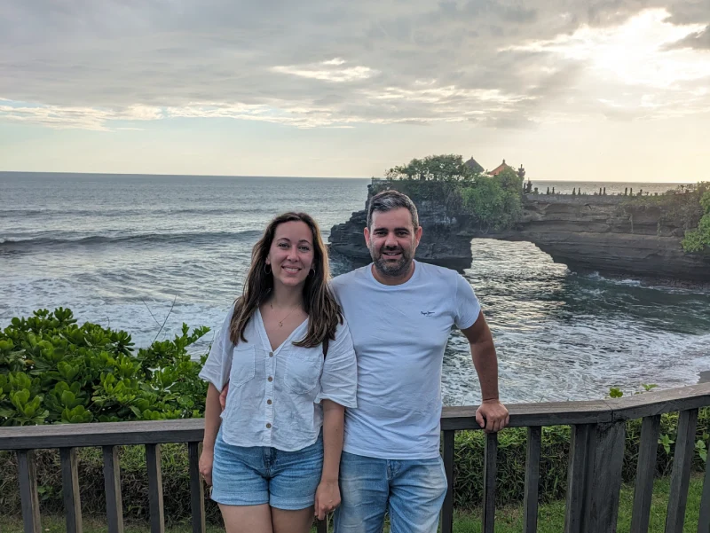 Disfrutando de las vistas de Tanah Lot Jordi y yo con el mar de fondo y una formación rocosa en forma de arco en el templo Tanah Lot, otro de los templos imprescindibles de Bali