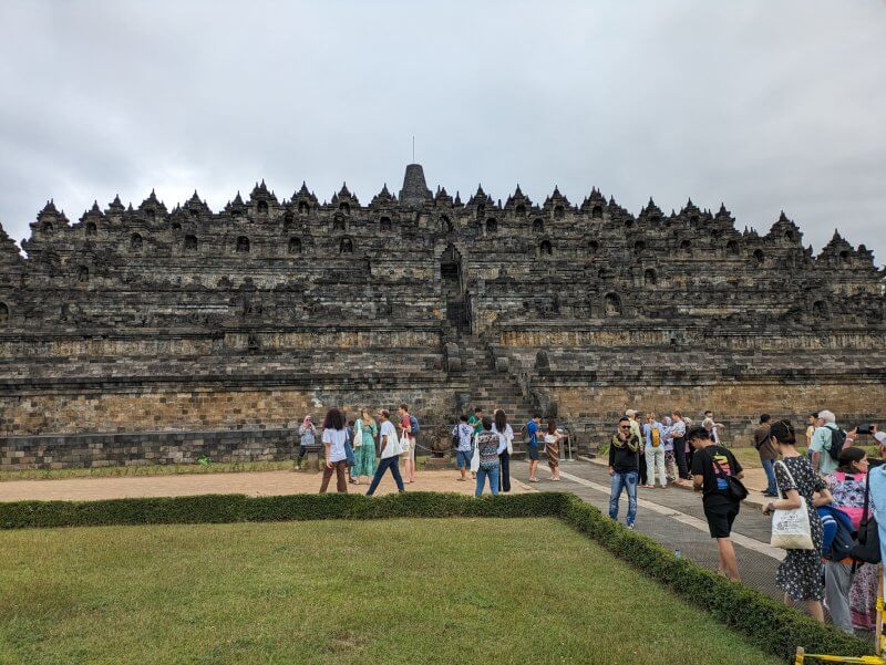 Vista del templo Borobudur desde abajo con bastantes turistas observandolo