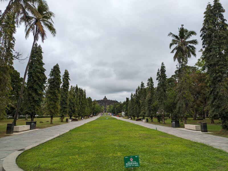 Paseo con hileras de arboles a ambos lados y el templo Borobudur al fondo